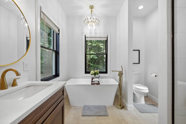 bathroom with tile patterned flooring, toilet, a bathing tub, and vanity