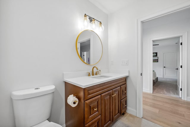 bathroom with vanity, toilet, and hardwood / wood-style floors