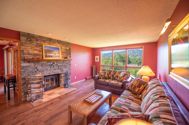 living room with wood-type flooring, a fireplace, and a textured ceiling