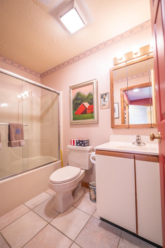 full bathroom with toilet, tile patterned floors, combined bath / shower with glass door, vanity, and a textured ceiling