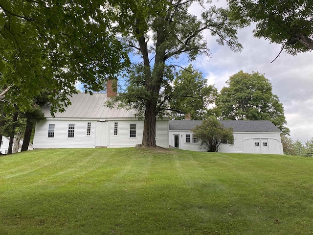 back of property featuring a lawn and a chimney