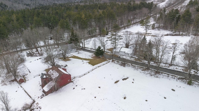 snowy aerial view featuring a forest view