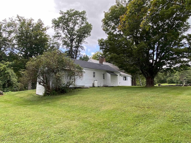 exterior space with a chimney and a yard