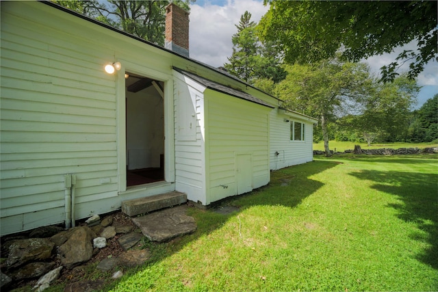 view of property exterior featuring a yard and a chimney