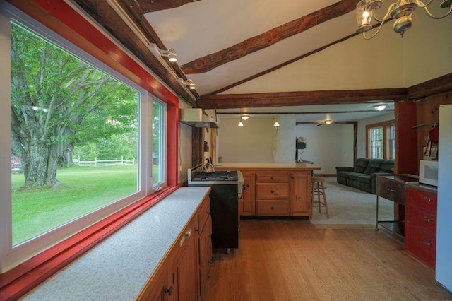 kitchen with vaulted ceiling with beams, light wood finished floors, light countertops, stove, and open floor plan