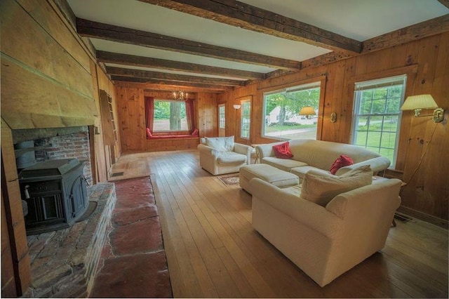 living area with wood walls, wood-type flooring, a chandelier, and beamed ceiling