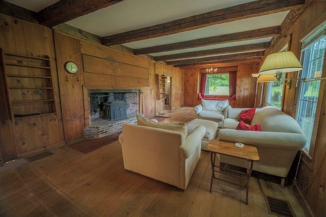 living room with visible vents, wooden walls, and hardwood / wood-style flooring