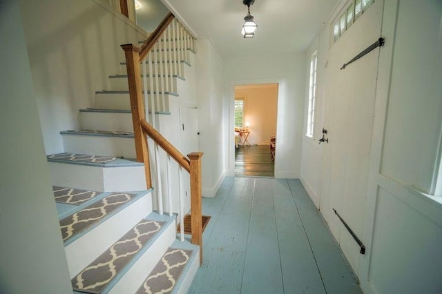 hallway with hardwood / wood-style flooring, stairs, and baseboards