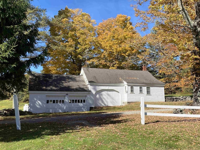 view of front facade with a garage, a chimney, and a front lawn