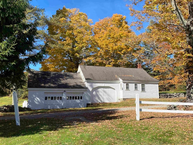 view of front of house with a front yard, a chimney, and an attached garage