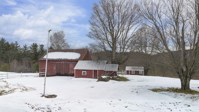 yard covered in snow with a garage and a barn