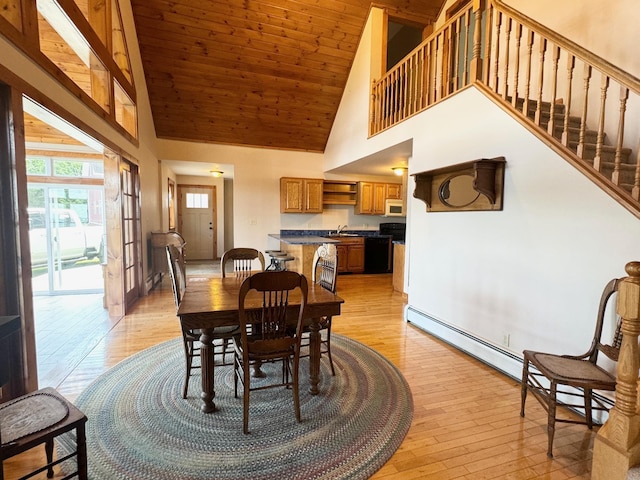 dining space featuring light wood finished floors, stairway, a baseboard heating unit, high vaulted ceiling, and wooden ceiling