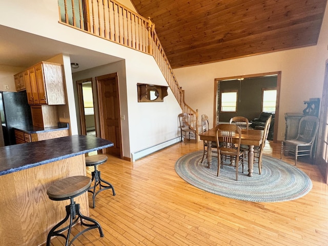 dining space with wood ceiling, a baseboard radiator, stairway, light wood-style floors, and high vaulted ceiling