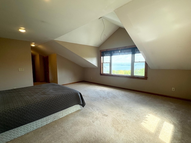 unfurnished bedroom with light carpet, baseboards, and vaulted ceiling