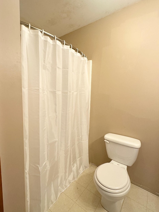 bathroom with toilet and tile patterned floors