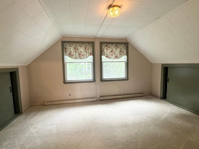 bonus room with a baseboard heating unit, light colored carpet, and vaulted ceiling