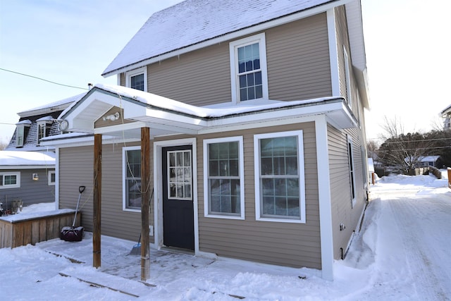 view of snow covered back of property