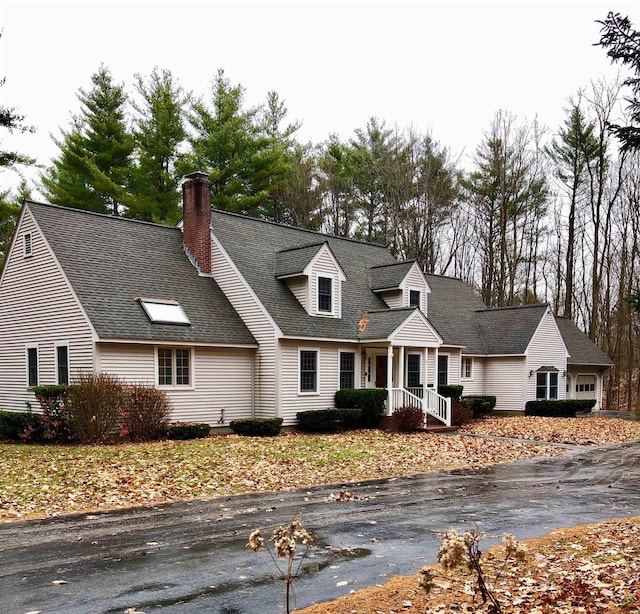 new england style home featuring roof with shingles