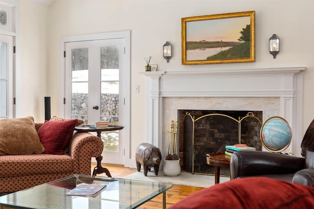 sitting room with wood finished floors and a high end fireplace