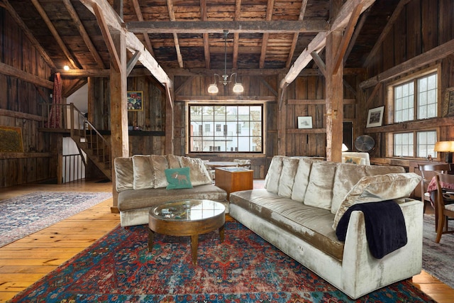 living area featuring wooden walls, stairs, and hardwood / wood-style flooring