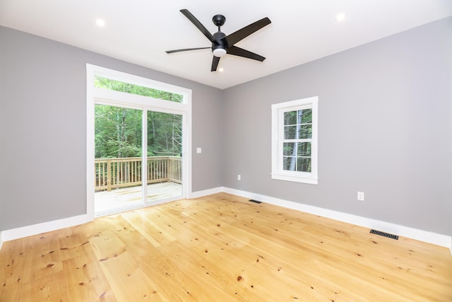 empty room featuring a healthy amount of sunlight, baseboards, and visible vents