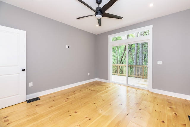 spare room featuring baseboards, visible vents, ceiling fan, and hardwood / wood-style floors