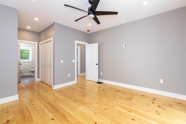 unfurnished bedroom with recessed lighting, a closet, ensuite bath, light wood-type flooring, and baseboards