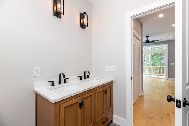 bathroom featuring wood finished floors, a sink, a ceiling fan, and recessed lighting