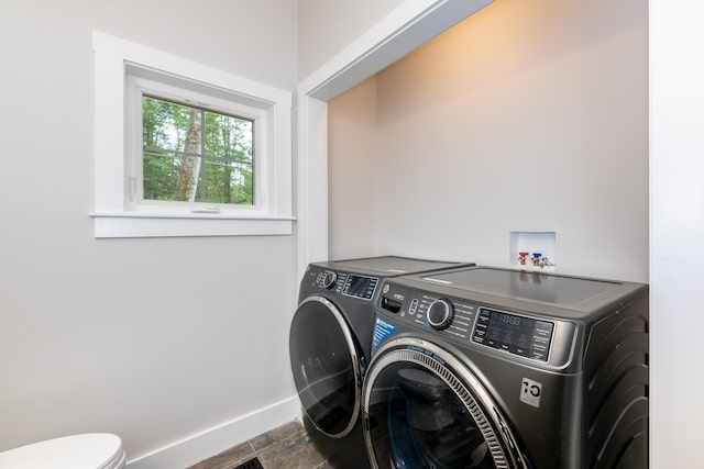 laundry room with laundry area, washing machine and clothes dryer, and baseboards