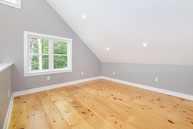 bonus room featuring lofted ceiling, light wood finished floors, and baseboards