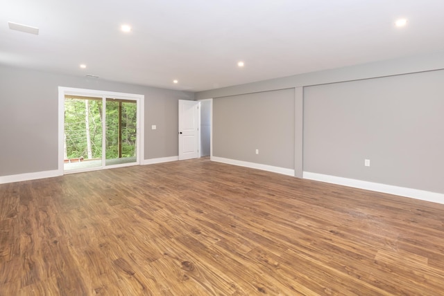 spare room featuring baseboards, wood finished floors, and recessed lighting