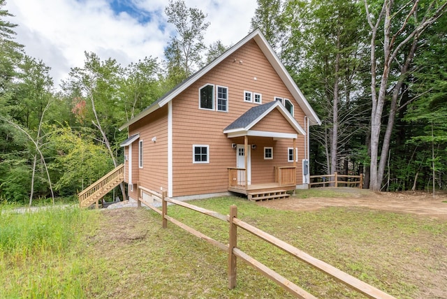 chalet / cabin with a front lawn and fence