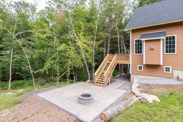 view of patio / terrace with stairway, a fire pit, and a deck