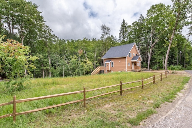 exterior space with a forest view and a fenced front yard