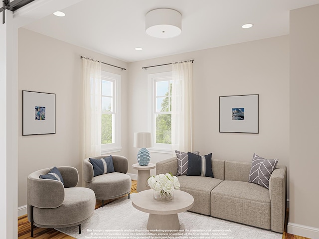 living area featuring a barn door, recessed lighting, wood finished floors, and baseboards