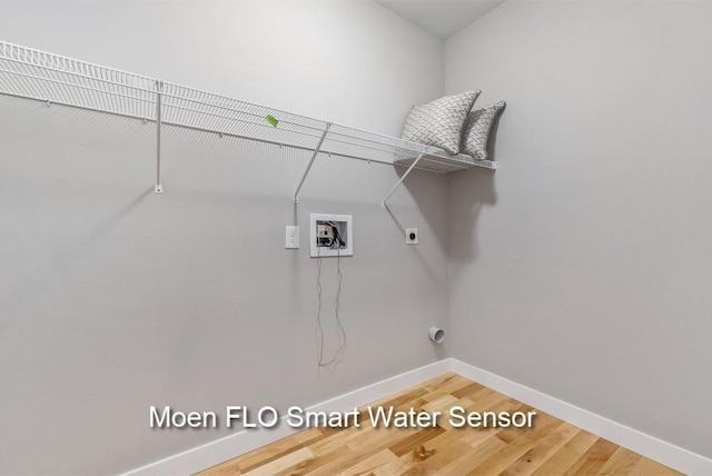 laundry room featuring hookup for a washing machine, hookup for an electric dryer, wood finished floors, laundry area, and baseboards