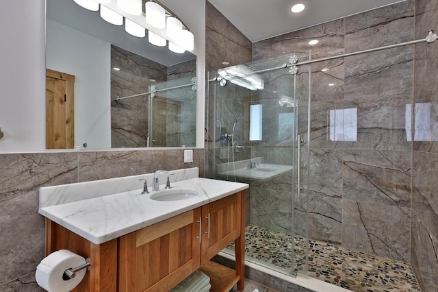 full bathroom featuring tile walls, vanity, and a marble finish shower