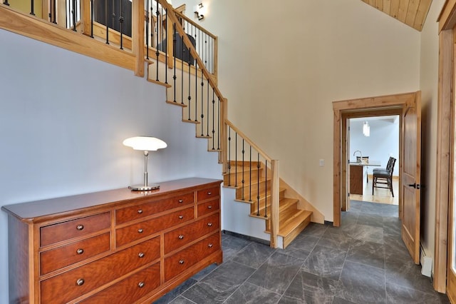 stairs with baseboards and high vaulted ceiling