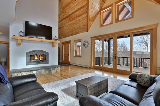 living room with wood finished floors, a stone fireplace, french doors, a baseboard heating unit, and high vaulted ceiling