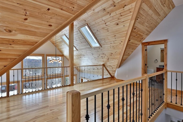 bonus room featuring a skylight, wood ceiling, an inviting chandelier, and wood finished floors