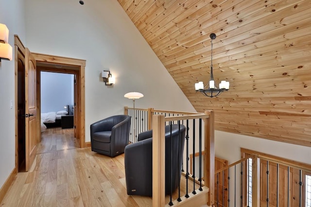 hallway featuring a chandelier, wood ceiling, wood finished floors, an upstairs landing, and high vaulted ceiling