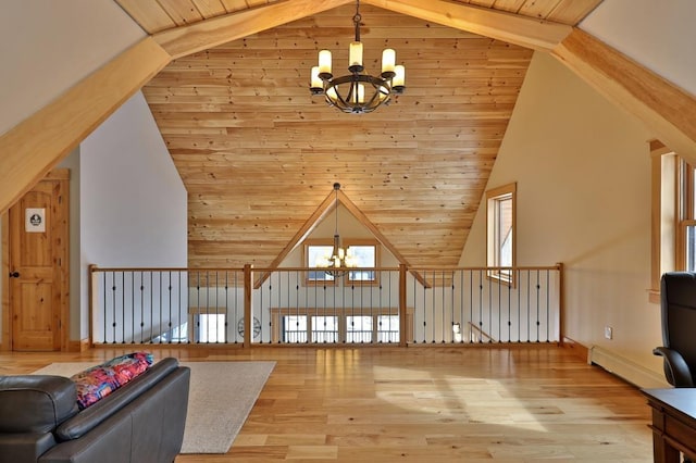 additional living space with high vaulted ceiling, a chandelier, wood finished floors, and a baseboard heating unit