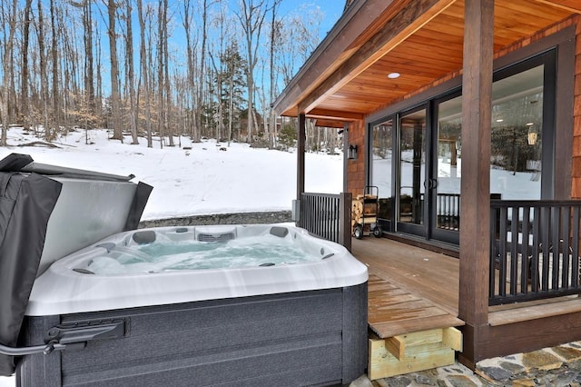 snow covered deck featuring a hot tub