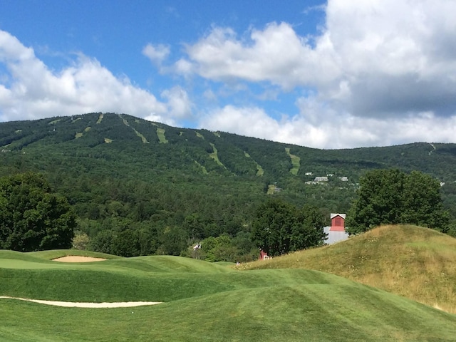 surrounding community featuring a yard, golf course view, and a mountain view