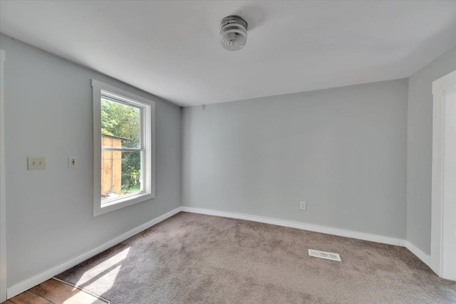 carpeted spare room with baseboards