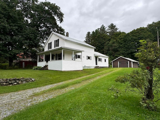 exterior space with a yard, a garage, covered porch, and an outdoor structure