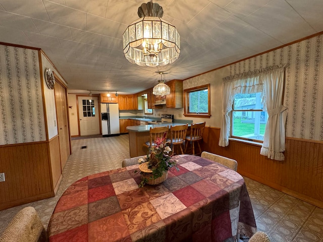 dining room featuring a notable chandelier and wooden walls