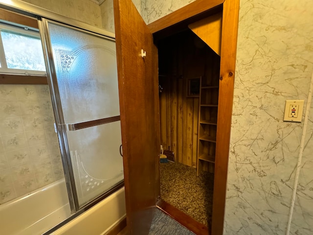 bathroom featuring bath / shower combo with glass door