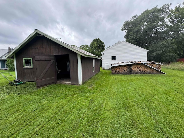 rear view of property featuring a lawn and a shed