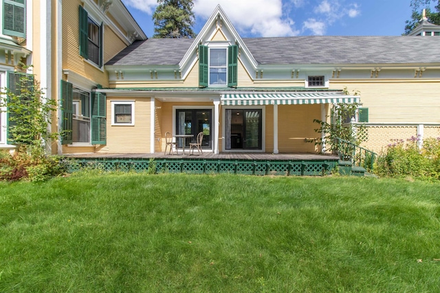 back of house featuring a lawn and a wooden deck